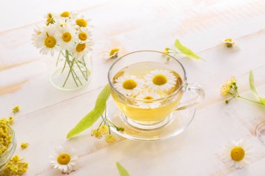 Ahşap masada sıcak papatya çayı Fincan