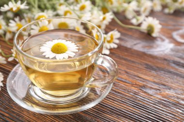 Ahşap masada sıcak papatya çayı Fincan