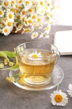 Gri masada sıcak papatya çayı Fincan