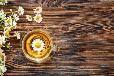 Ahşap masada sıcak papatya çayı Fincan