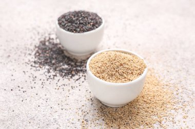 Hafif arka planda farklı haşhaş tohumu ile Kaseler