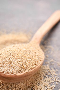 Gri arka planda beyaz haşhaş tohumu ile Kaşık, closeup