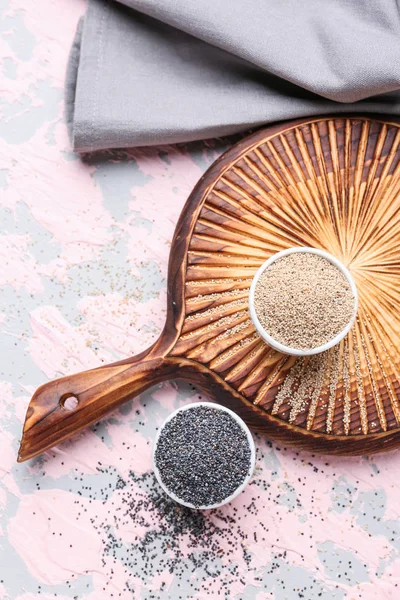 Bowls with different poppy seeds on color background — Stock Photo, Image