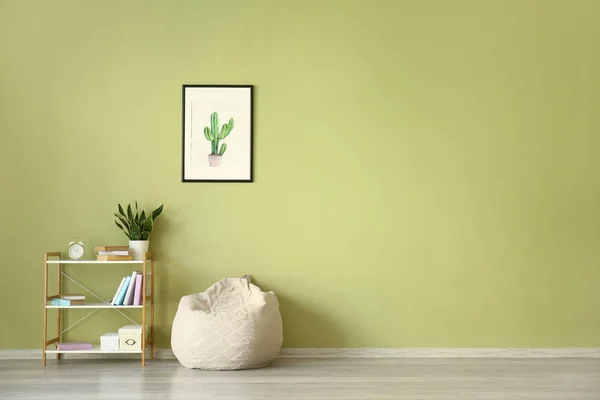 Beanbag and shelf unit near color wall with picture — Stock Photo, Image