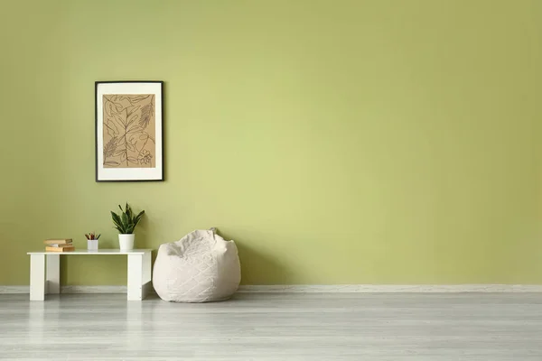 Saco de feijão e mesa perto da parede de cor com imagem — Fotografia de Stock