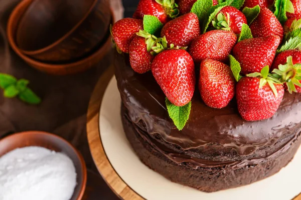 Stand con sabroso pastel de chocolate en la mesa — Foto de Stock