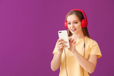 Renkli arka planda müzik dinleyen güzel genç bir kadın.