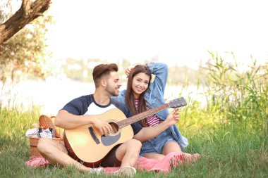 Parkta piknik gitar ile genç çift