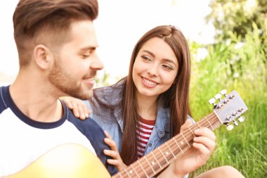 Parkta piknik gitar ile genç çift