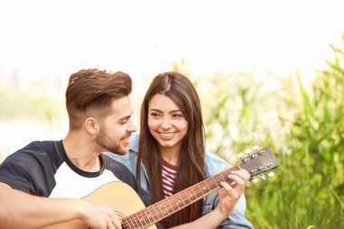 Parkta piknik gitar ile genç çift