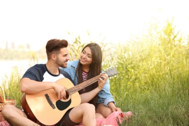 Parkta piknik gitar ile genç çift