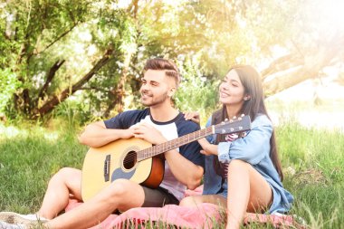 Parkta piknik gitar ile genç çift