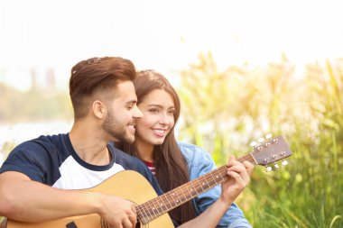 Parkta piknik gitar ile genç çift