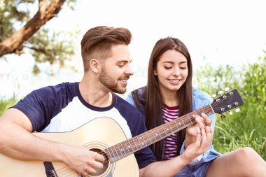 Parkta piknik gitar ile genç çift