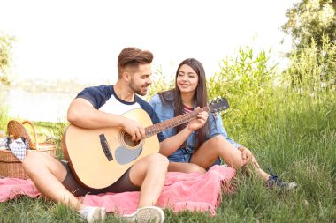 Parkta piknik gitar ile genç çift