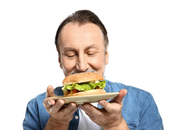 Porträt eines hübschen reifen Mannes mit leckerem Burger auf weißem Hintergrund — Stockfoto