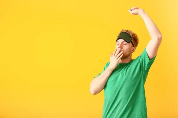 Sleepy man with mask on color background — Stock Photo, Image