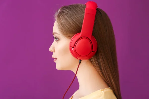Belle jeune femme écoutant de la musique sur fond de couleur — Photo