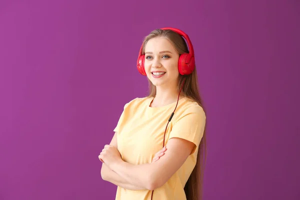 Όμορφη νεαρή γυναίκα που ακούει μουσική με φόντο το χρώμα — Φωτογραφία Αρχείου