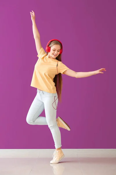 Danse jeune femme écouter de la musique et danser contre le mur de couleur — Photo