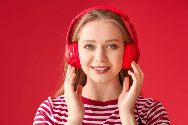 Belle jeune femme écoutant de la musique sur fond de couleur — Photo