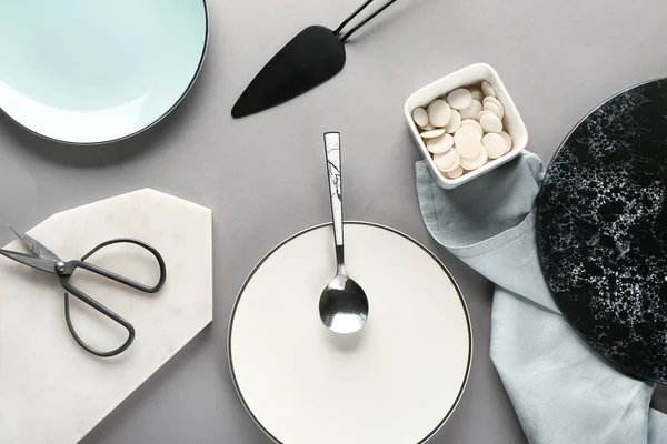 Louça e utensílios de cozinha diferentes em fundo cinza — Fotografia de Stock