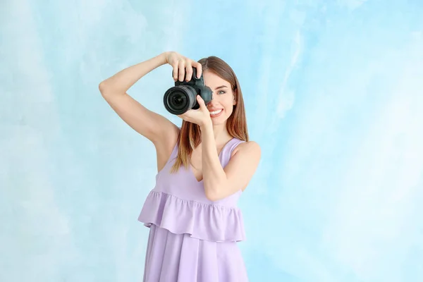 Молодая женщина фотограф на цветном фоне — стоковое фото