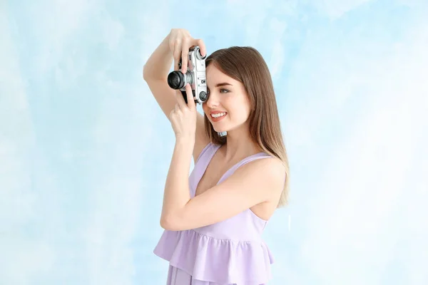 Ung kvinnlig fotograf på färg bakgrund — Stockfoto