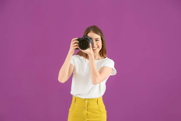 Jonge vrouwelijke fotograaf op kleur achtergrond — Stockfoto