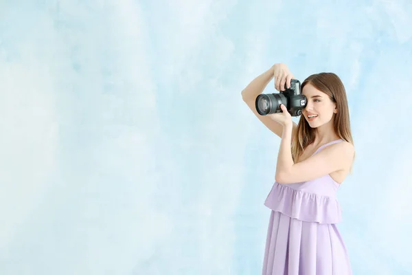 Jonge vrouwelijke fotograaf op kleur achtergrond — Stockfoto