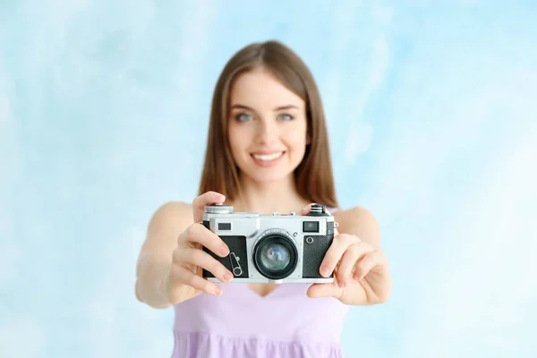 Jonge vrouwelijke fotograaf op kleur achtergrond — Stockfoto