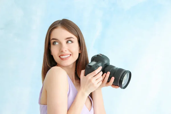 Jonge vrouwelijke fotograaf op kleur achtergrond — Stockfoto