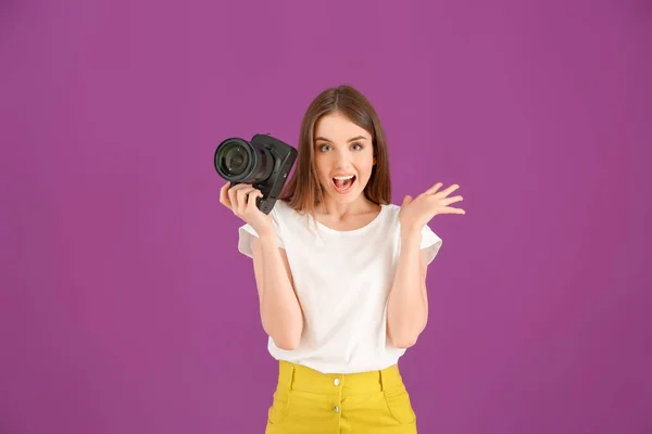 Opgewonden vrouwelijke fotograaf op kleur achtergrond — Stockfoto