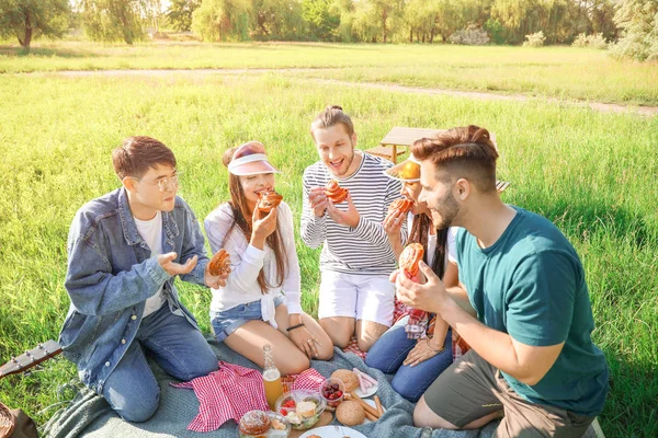 Happy friends on picnic in park