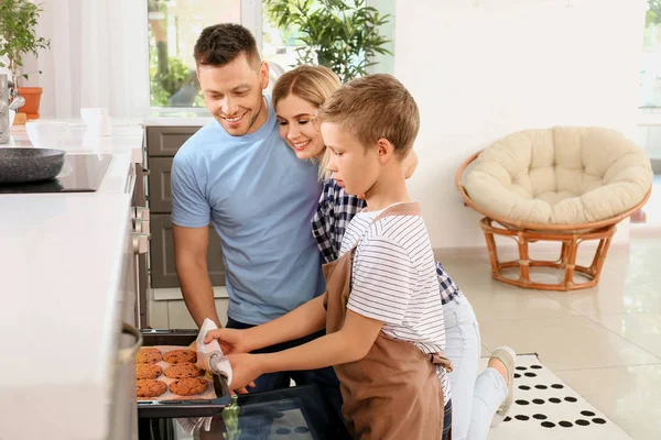 Happy family baking tasty cookies at home — Stock Photo, Image