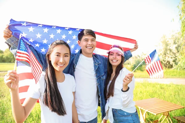 Young people with USA flags outdoors. Independence Day celebration — Stock Photo, Image