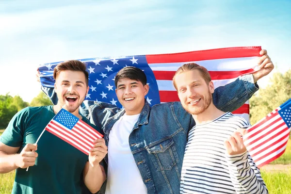 A fiatal férfiak az USA-zászlók a szabadban. Függetlenség napja ünneplése — Stock Fotó