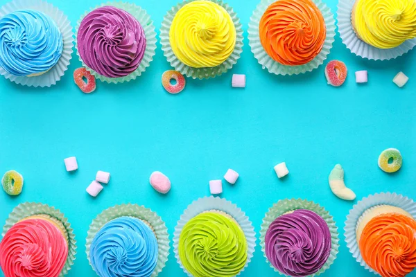 Сладкие вкусные кексы с леденцами на цветном фоне — стоковое фото