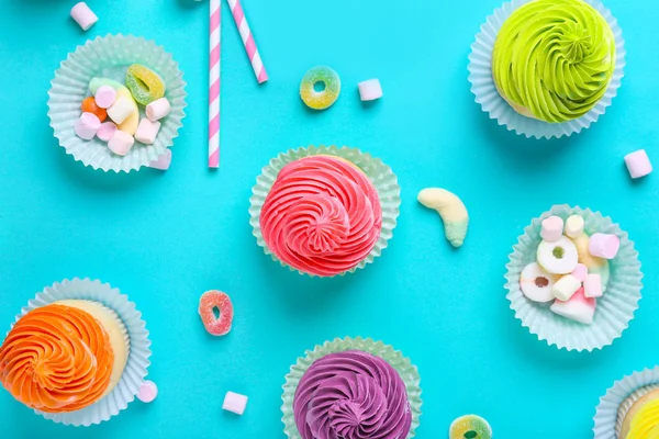 甜甜美味的纸杯蛋糕与糖果的颜色背景 — 图库照片