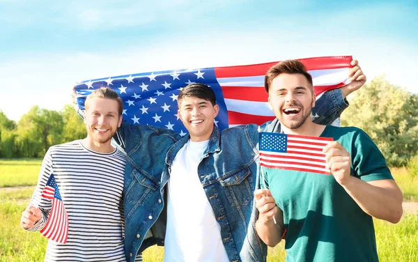 Young men with USA flags outdoors. Independence Day celebration — Stock Photo, Image