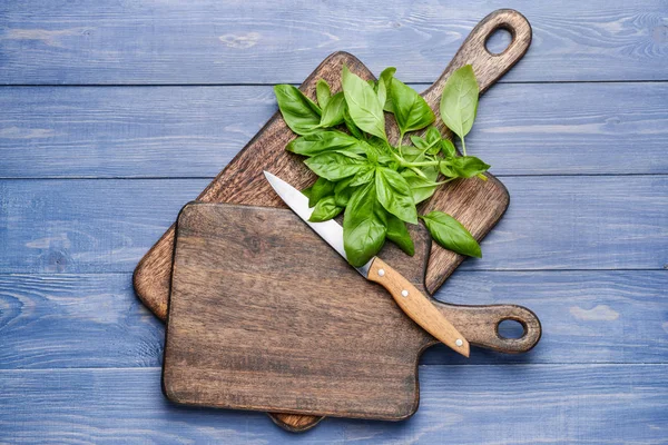 Wooden boards with fresh basil and knife on table — Stock Photo, Image