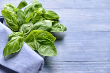 Ahşap masa üzerinde peçete ile taze fesleğen