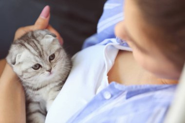 Evde sevimli küçük kedi yavrusu ile güzel genç kadın