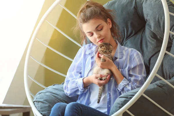Hermosa mujer joven con lindo gatito en casa — Foto de Stock