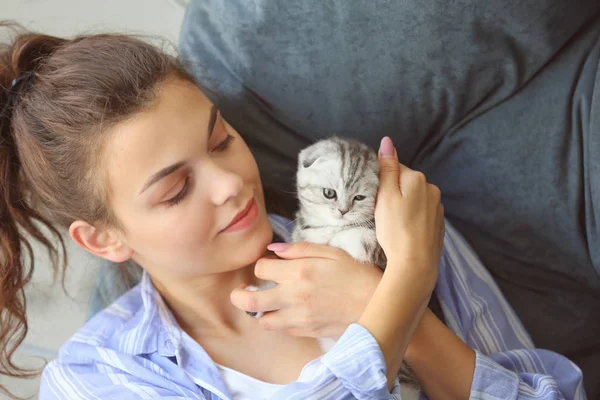 Beautiful young woman with cute little kitten at home — Stock Photo, Image