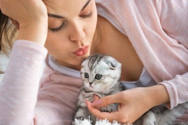 Evde sevimli küçük kedi yavrusu ile güzel genç kadın