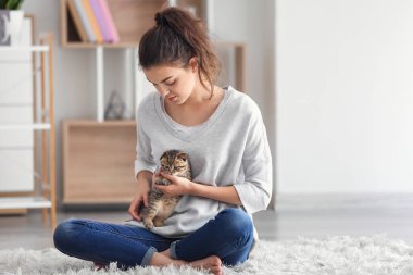 Evde sevimli küçük kedi yavrusu ile güzel genç kadın