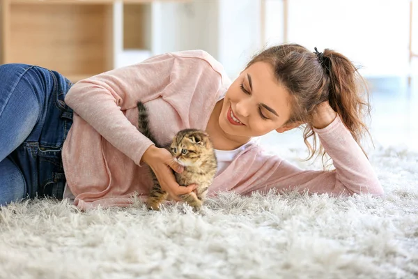 Beautiful young woman with cute little kitten at home — Stock Photo, Image
