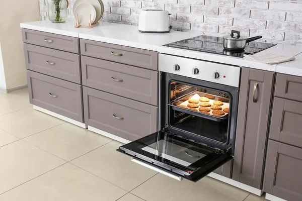 Open oven with tasty homemade cookies in kitchen — Stock Photo, Image