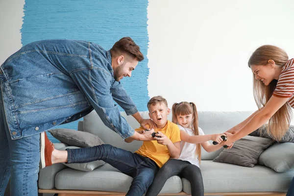 Parents trying to take joypads from children with addiction to video games at home — Stock Photo, Image